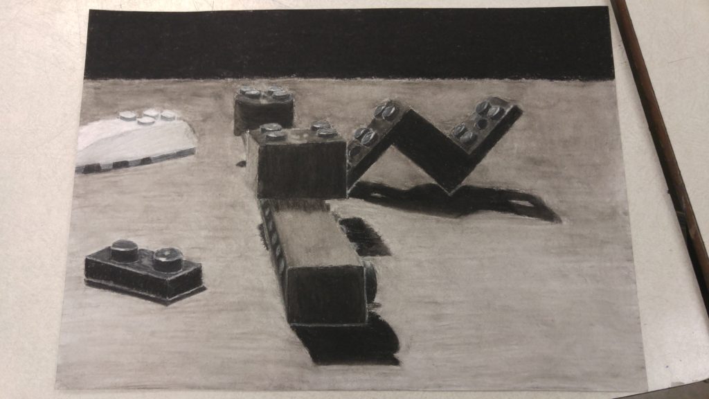 A drawing of several Lego pieces done in charcoal