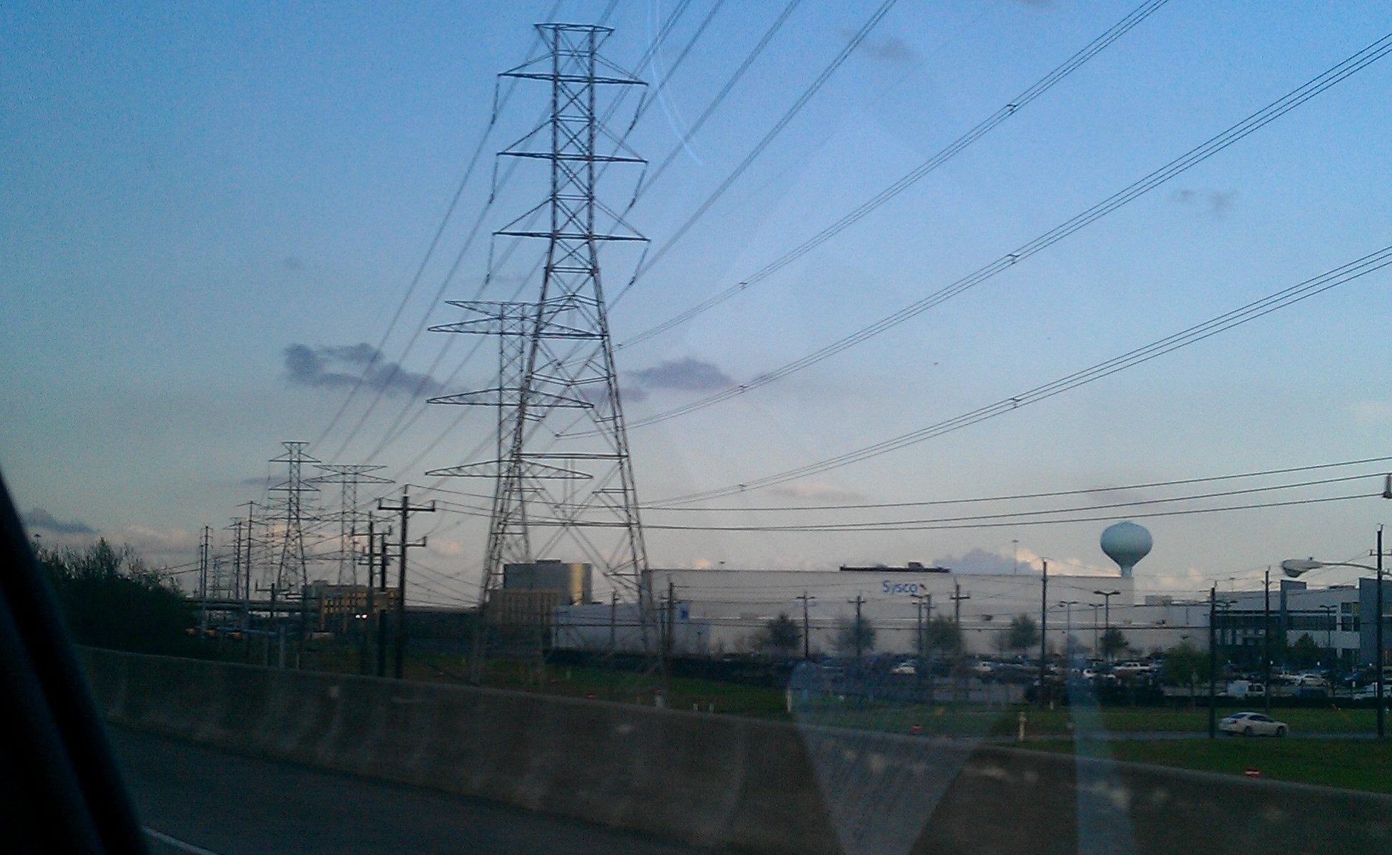 Photo of power lines through a car window as the sun sets