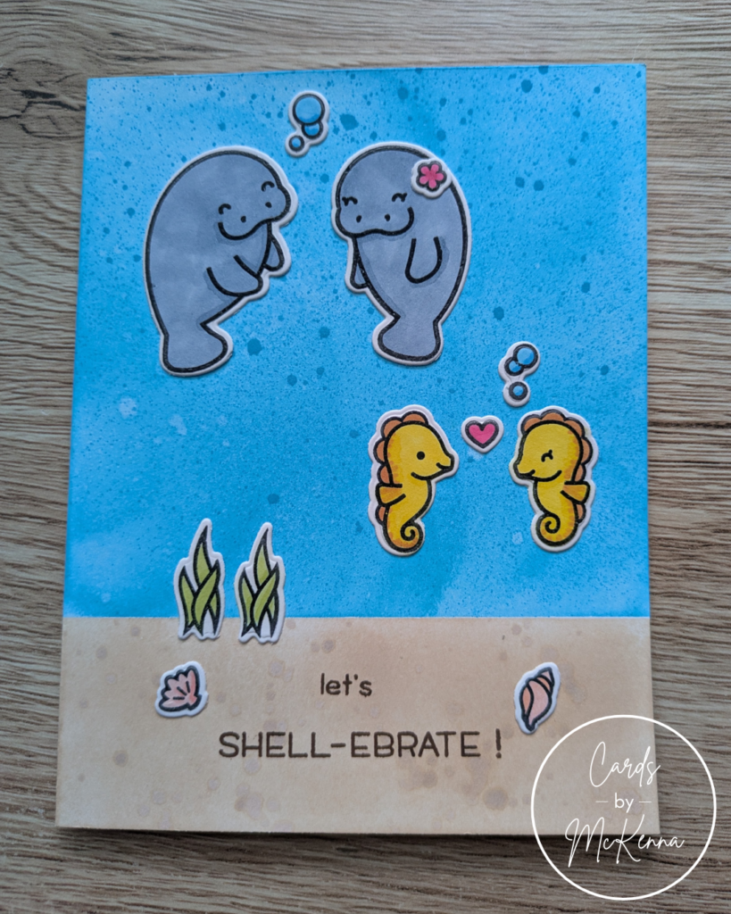 A handmade card with two manatees and two seahorses in a cute drawing style. The background is a bit blue ocean with a sandy ocean floor. The card reads "Let's Shell-ebrate"