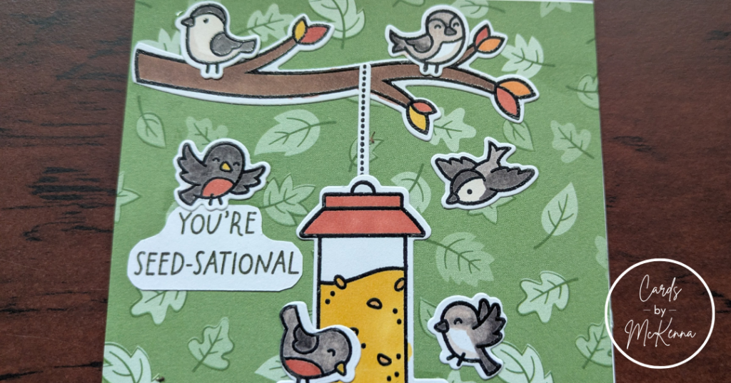 A closer view of the top half of the same card, focusing on the top branch, top of the bird feeder, and "You're Seed-sational" sentiment